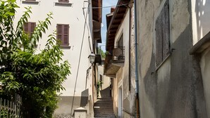 A narrow stone pathway leading to a building with a staircase. - 'Crooked House' Apartment with Mountain View, Private Garden and Parking (Naggio)