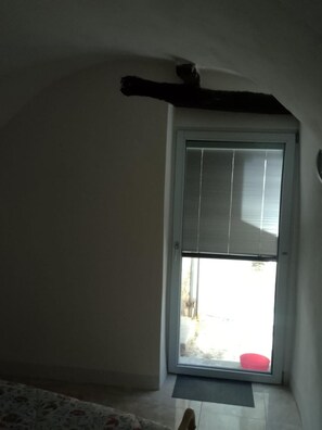 Una habitació amb un finestral gran, una porta i una catifes amb dibuixos.