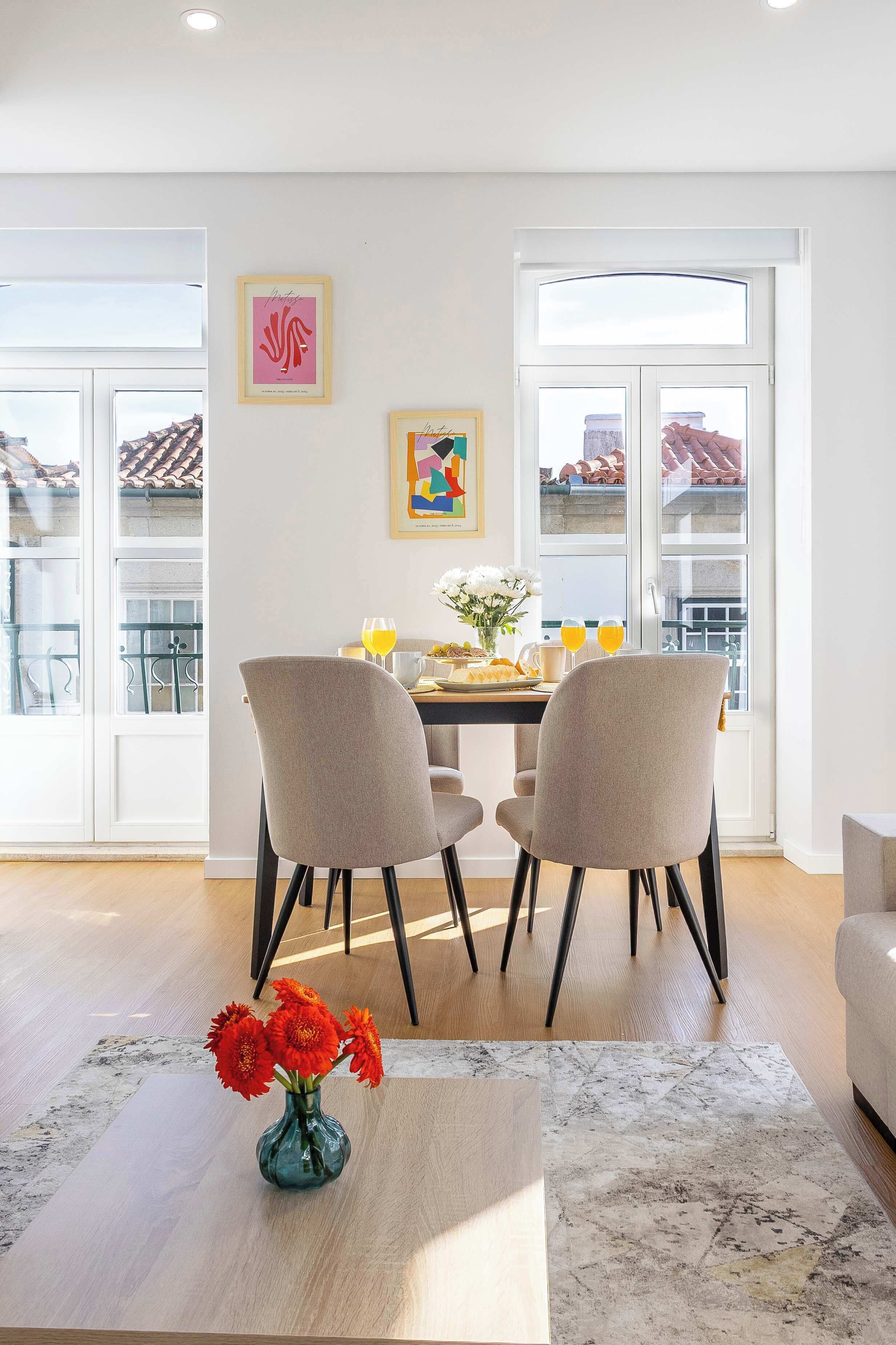 Un'area dedicata al dining con tavolo, sedie e un vaso con fiori.