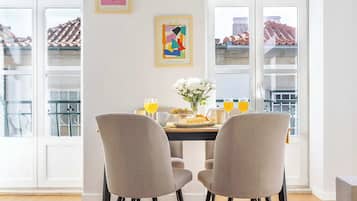 A dining area with a table, chairs, and a vase with flowers.