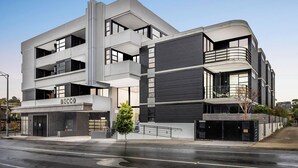 Un bâtiment moderne à plusieurs étages, doté d’un toit plat, de grandes fenêtres et d’une devanture bien visible portant l’inscription « DECCO ».