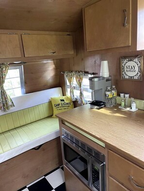 A compact kitchenette with a microwave, coffee maker, and storage cabinets. - Sweet Camper Ideal for a Romantic Escape in Gatlinburg, Tennesse (Gatlinburg)