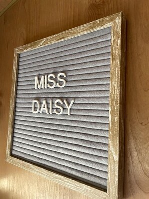 Eine gerahmte Nachrichtentafel mit dem Schriftzug 'MISS DAISY'.