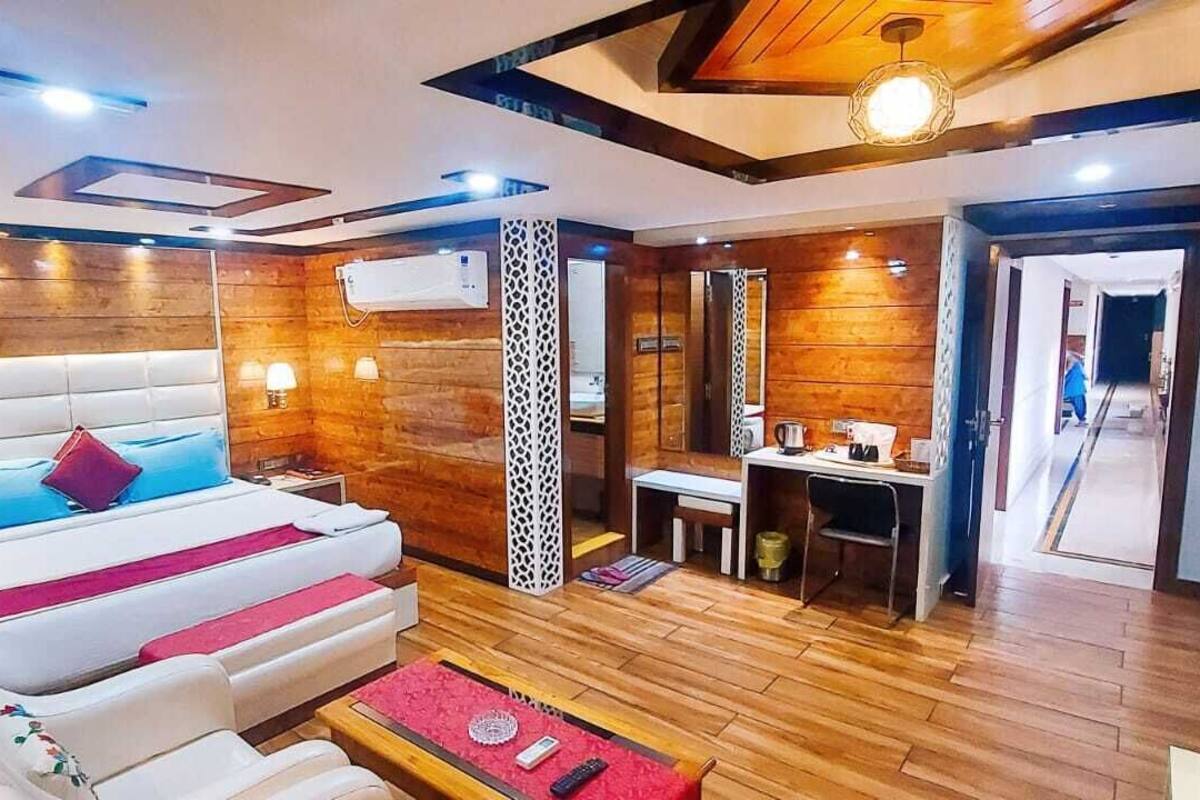 Habitación de hotel con una cama grande, un escritorio, una silla y un televisor.