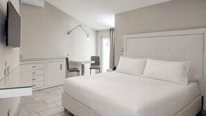 Una habitación de hotel moderna con cama, escritorio y silla.