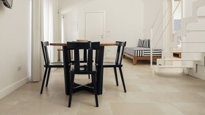 Un interior moderno con comedor, una escalera y una cama.
