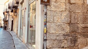 Una calle con una señal de no estacionamiento, un letrero que dice 'amboilati' y una señal direccional hacia 'Tempio di Diana'.