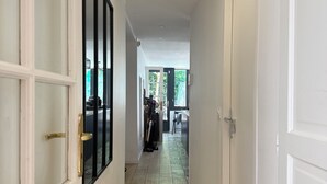 A hallway with white doors, a tiled floor, and recessed ceiling lights. - Air-conditioned family home with a pool near Lyon (Sathonay-Camp)