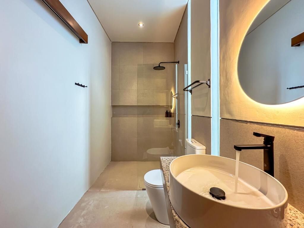 Ein modernes Badezimmer mit einem großen Waschbecken, einer Toilette und einer Duschkabine.