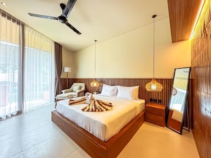 A hotel room with a large bed, a ceiling fan, a nightstand, a lamp, and a view of the outdoors. - Poh Canggu (Badung)