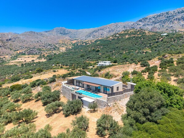 A modern villa with a swimming pool, surrounded by olive trees and mountains. - Rodia Luxury villa ,Sea View Retreat near Plakias (Plakias)