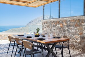 A table set outdoors with a view of the sea and mountains. - Rodia Luxury villa ,Sea View Retreat near Plakias (Plakias)