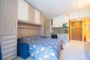 A compact bedroom with a bed, a small kitchenette, and a bathroom. - Le Palme by Wonderful Italy (Sanremo)