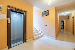 A hallway with an elevator, a staircase, and a door leading to another room. - Le Palme by Wonderful Italy (Sanremo)