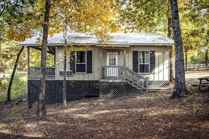 A cabin with a porch, a covered deck, and a fenced yard. - Scenic Waterfront Cabin with Covered Porch Overlooking Private Pond near Zwolle, Louisiana (Zwolle)