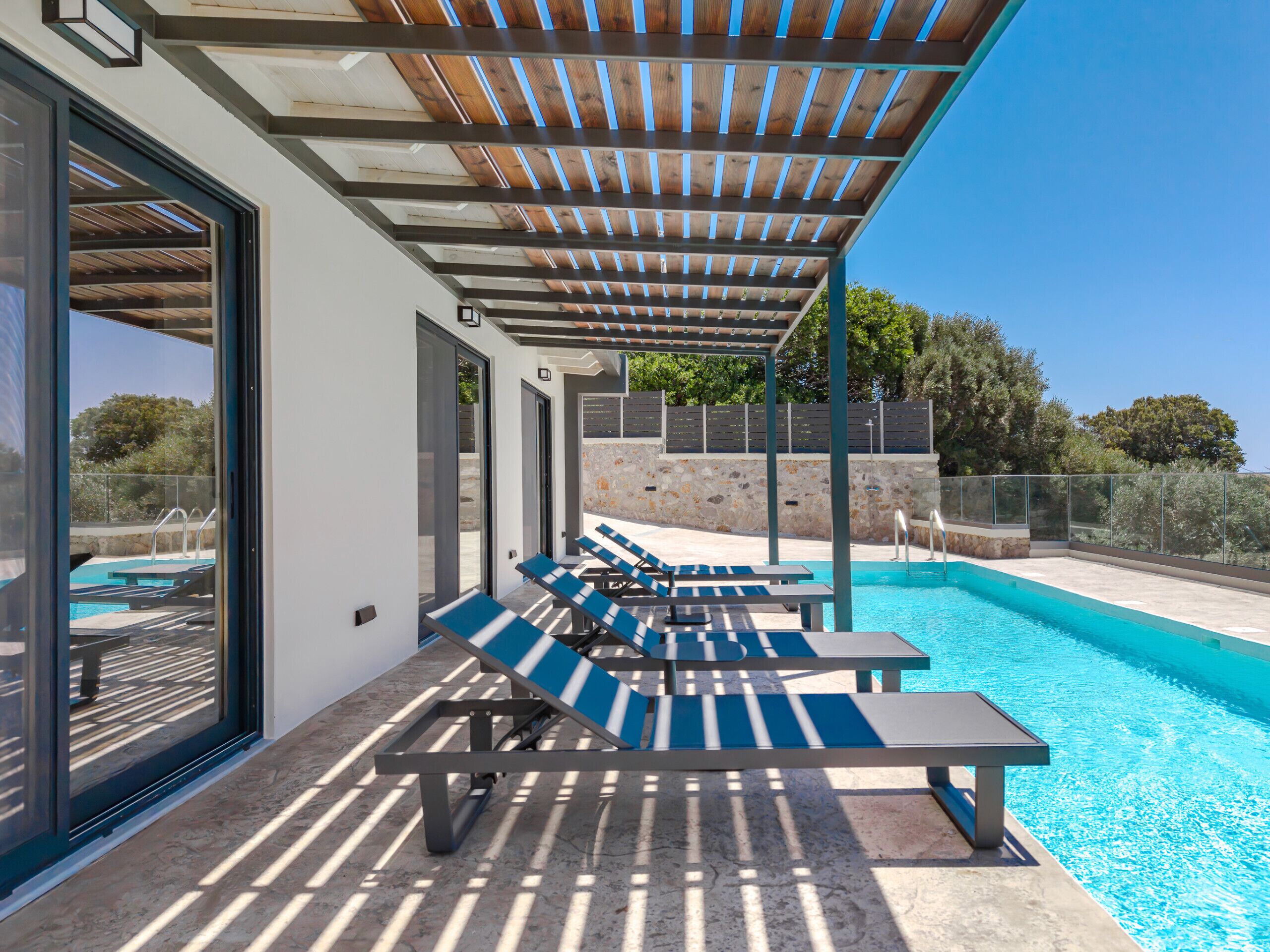 A poolside area with lounge chairs and a pergola.