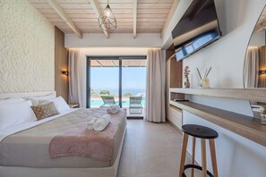 Ein Hotelzimmer mit Bett, Schreibtisch, Stuhl, Fernseher und Meerblick.