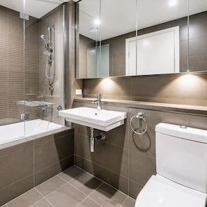 A modern bathroom with a glass-enclosed shower, a white sink, and a toilet. - Stylish Apartment Sydney Olympic Park Free parking (Sydney Olympic Park)