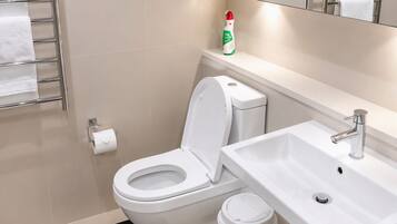 A modern bathroom with a toilet, sink, and towel rack.