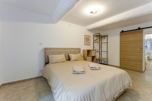 Una camera da letto con un letto, comodini, un armadio e vista all'esterno.