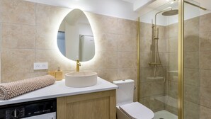 A modern bathroom with a round sink, a toilet, a glass-enclosed shower, and a built-in washing machine. - Petit Pont d'Avignon — apartment with terrace & A/C (Villeneuve-lès-Avignon)