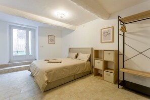 Une chambre à coucher avec un lit, une table de chevet, une armoire et une fenêtre.