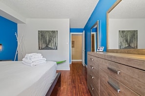 Ein Hotelzimmer mit einem Bett, einer Holzkommode und zwei Bildern an den Wänden.
