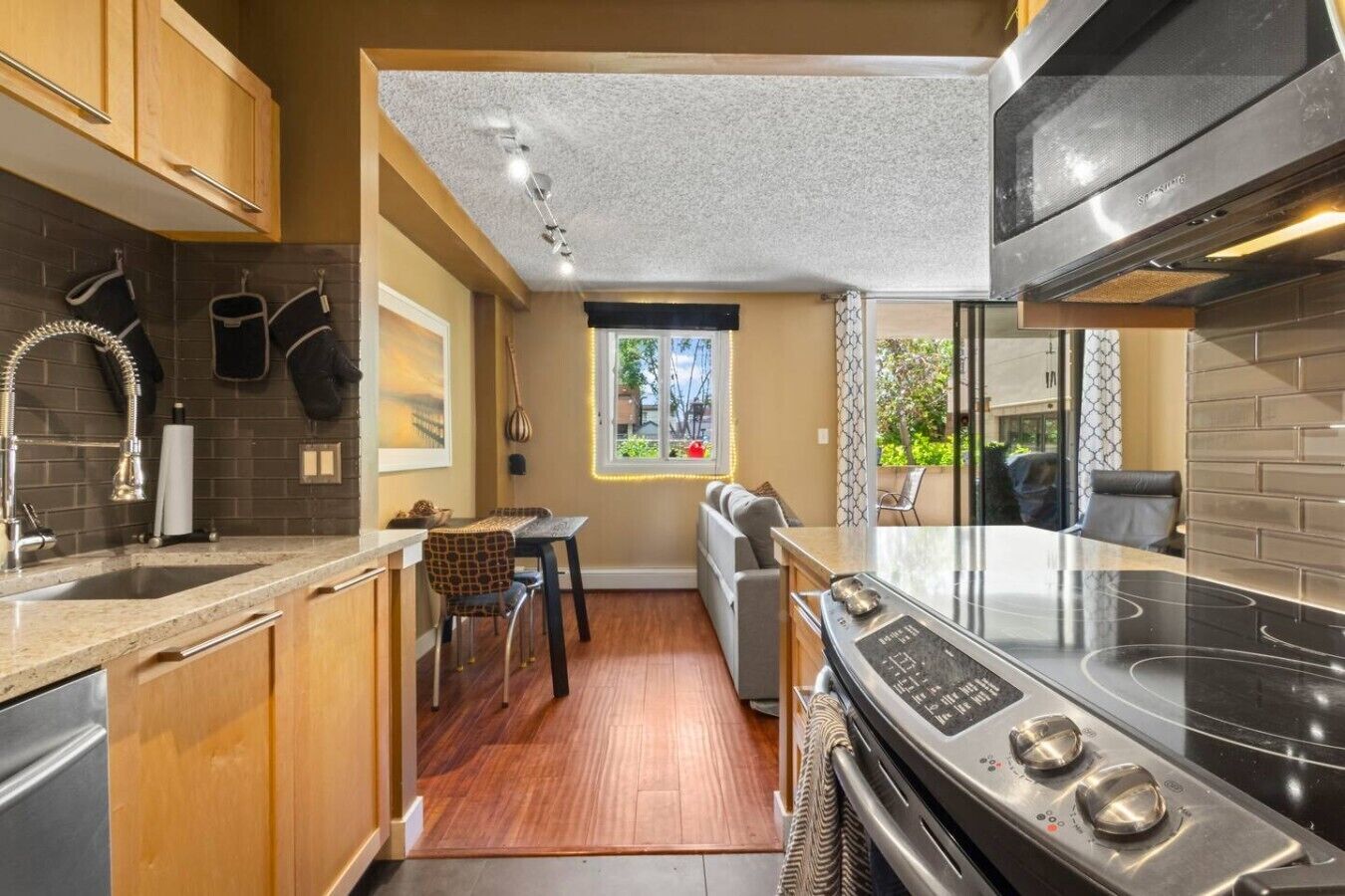 Una cocina compacta con horno integrado, zona de comedor y ventana con vistas.