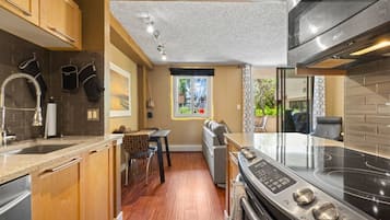 Una cocina compacta con horno integrado, zona de comedor y ventana con vistas.