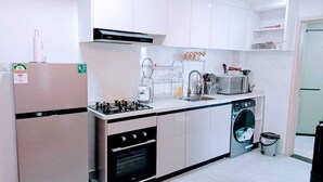 A compact kitchen with a gas stove, oven, sink, and dishwasher.
