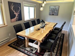 Un comedor con una mesa de madera, sillas negras y una alfombra.