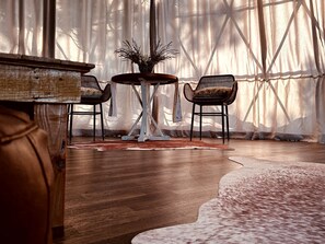 A room with a wooden floor, a round table with chairs, and a decorative vase. - Stunning Secluded Dome with Gorgeous Forest Sights in Hermosa, South Dakota (Hermosa)