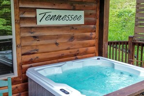 Eine Holzhütte mit Whirlpool und einem Schild, auf dem 'Tennessee' steht.