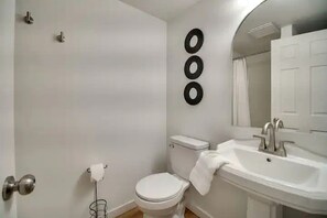 A bathroom with a toilet, sink, and mirror. - Cozy Studio Retreat with Scenic 5-Acre Views, Near City Lake & Cherokee Casino in Gentry, Arkansas (Gentry)