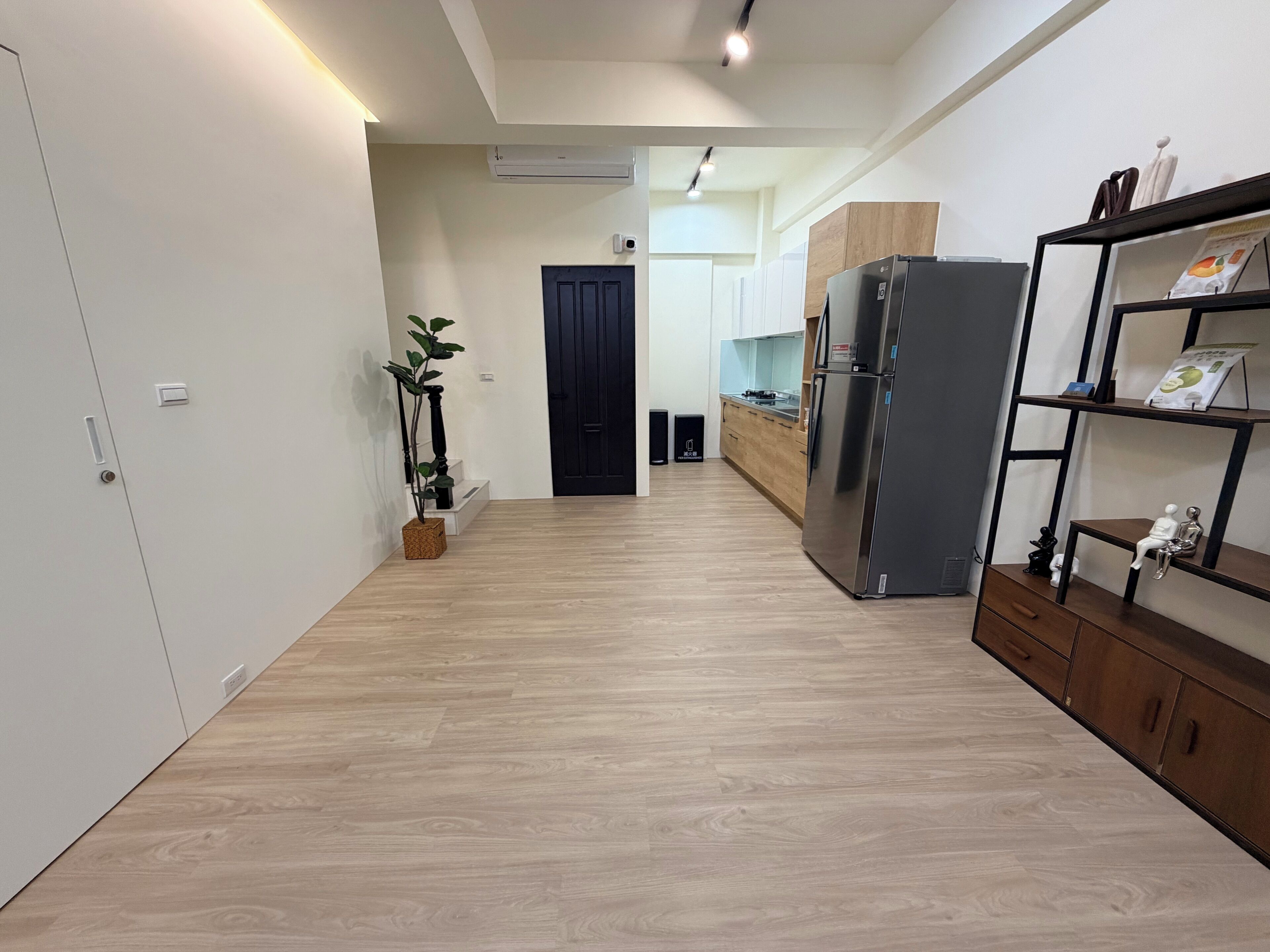 A modern kitchen with a built-in refrigerator, wooden cabinets, and a plant.
