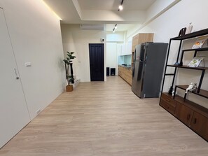 Eine moderne Küche mit Einbaukühlschrank, Holzschränken und einer Pflanze.