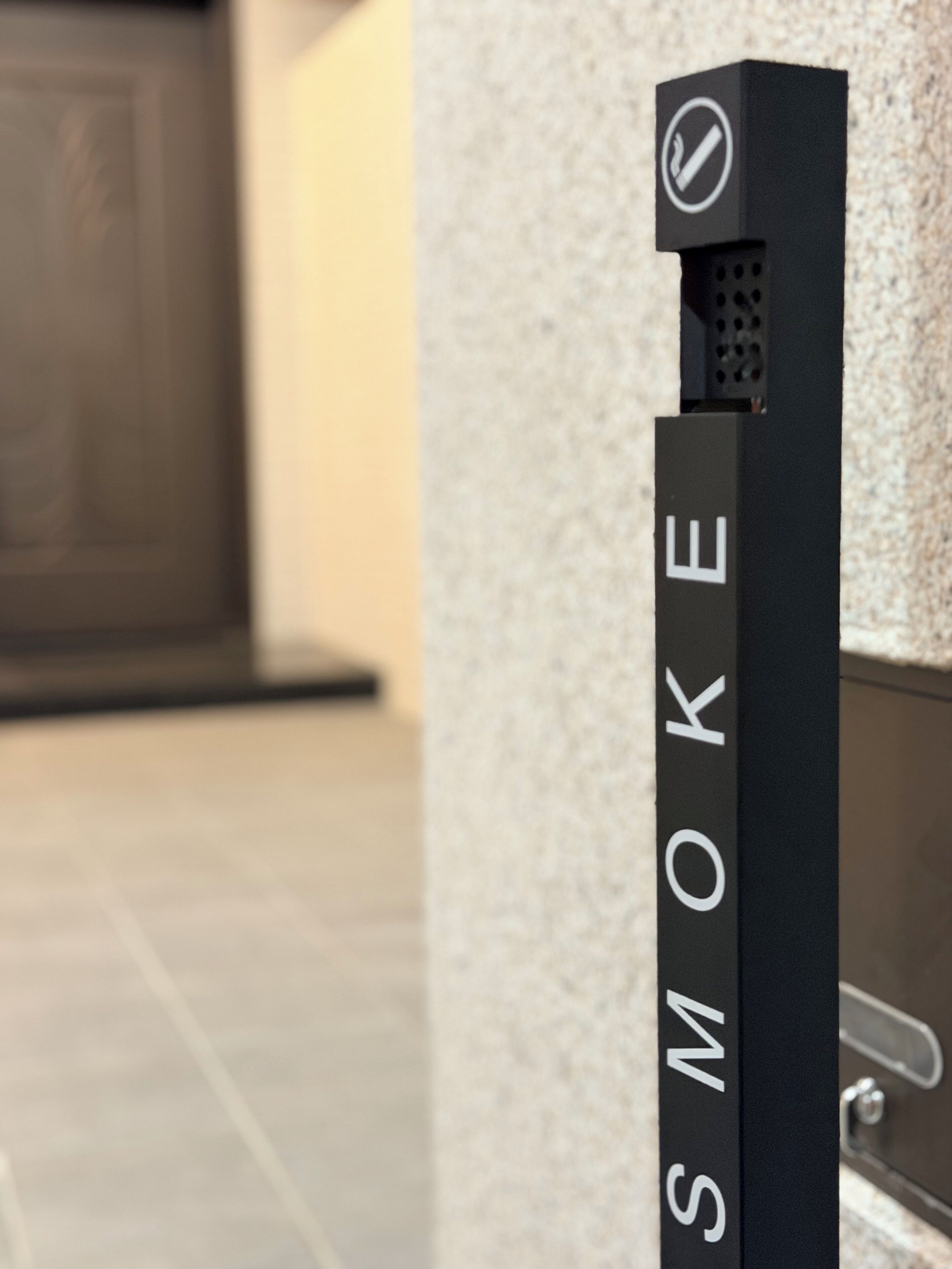 A black vertical object with the text 'SMOKE' and a no-smoking symbol.