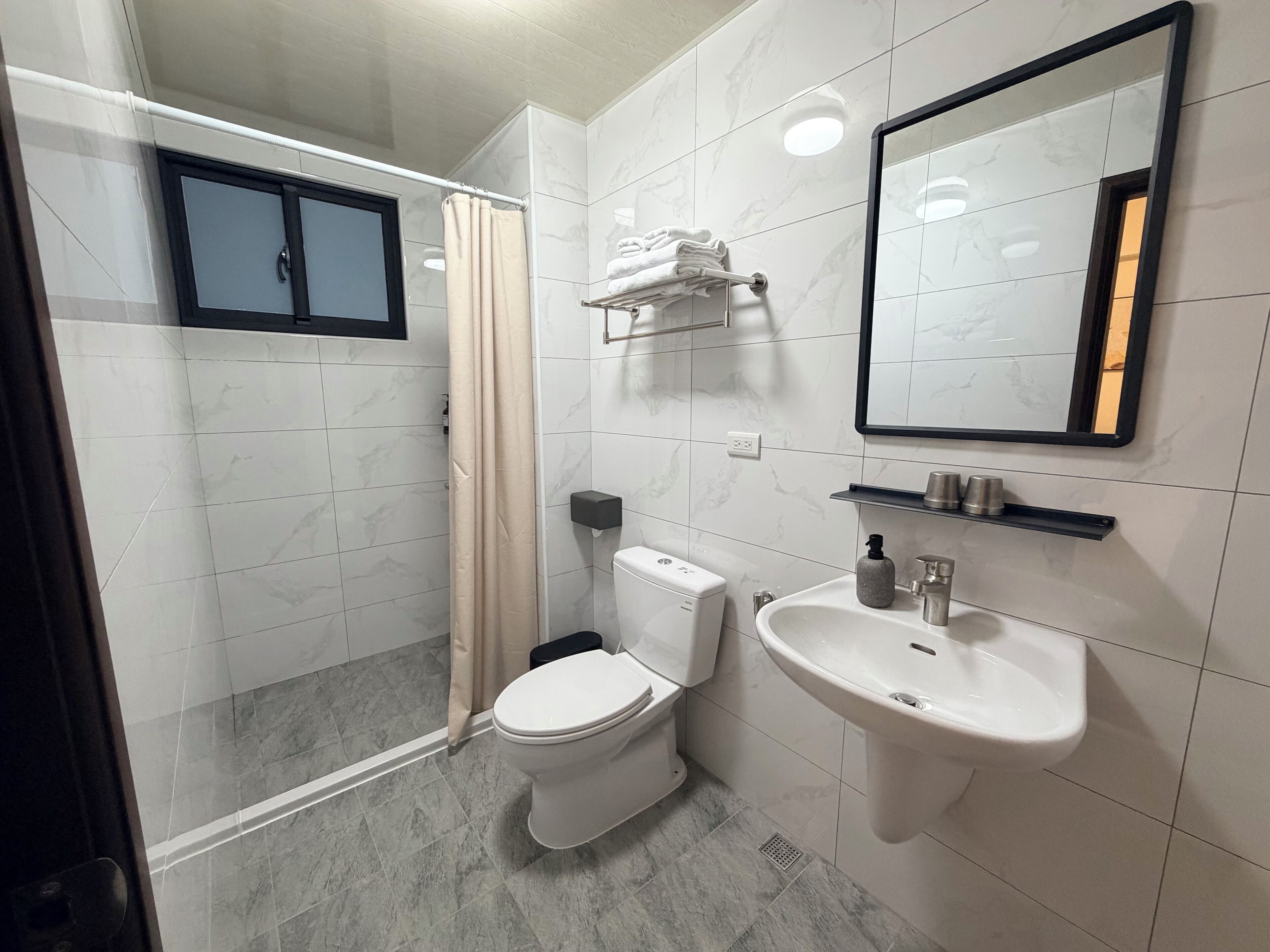 A bathroom with a toilet, sink, and shower.