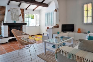 Ein Wohnzimmer mit Kamin, Fernseher und einer Couch.