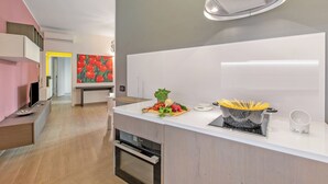 Una cocina moderna con horno empotrado, encimera blanca y salpicadero.