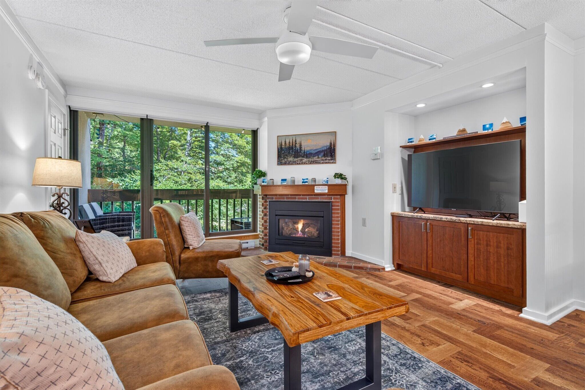 A living room with a fireplace, a sofa, a coffee table, and a TV.