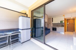 Eine moderne Wohnung mit Küchenzeile, einem Essbereich mit Tisch und Stühlen sowie einer Glastür zu einem Wohnraum.