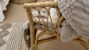 A cozy interior with wicker furniture, a patterned rug, and a small table with candles.