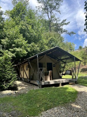 Un chalet rustique doté d’une terrasse en bois, entouré d’arbres.
