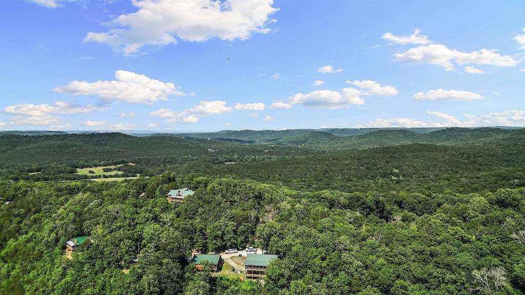 A forested landscape with scattered buildings, likely a resort or lodge, under a clear sky.