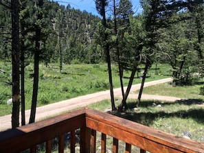 A wooden deck with a dirt road in the background.