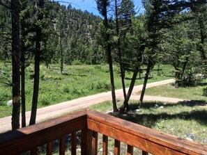 A wooden deck with a dirt road in the background.
