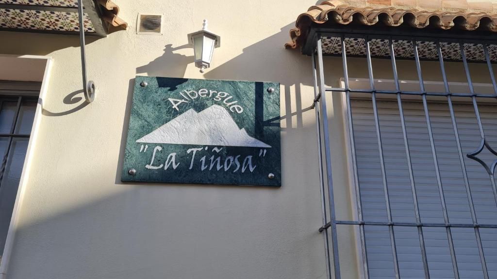 Un edifici amb un cartell que diu 'Albergue La Tinosa'.