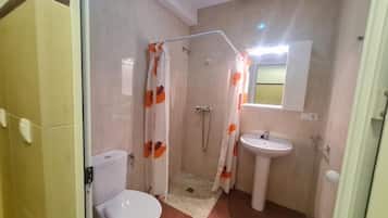 Un baño con ducha, inodoro y lavabo.