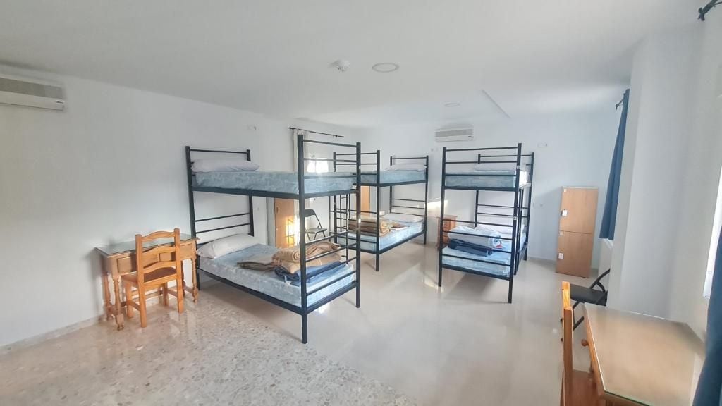 Un dormitorio con literas, un escritorio y una silla.
